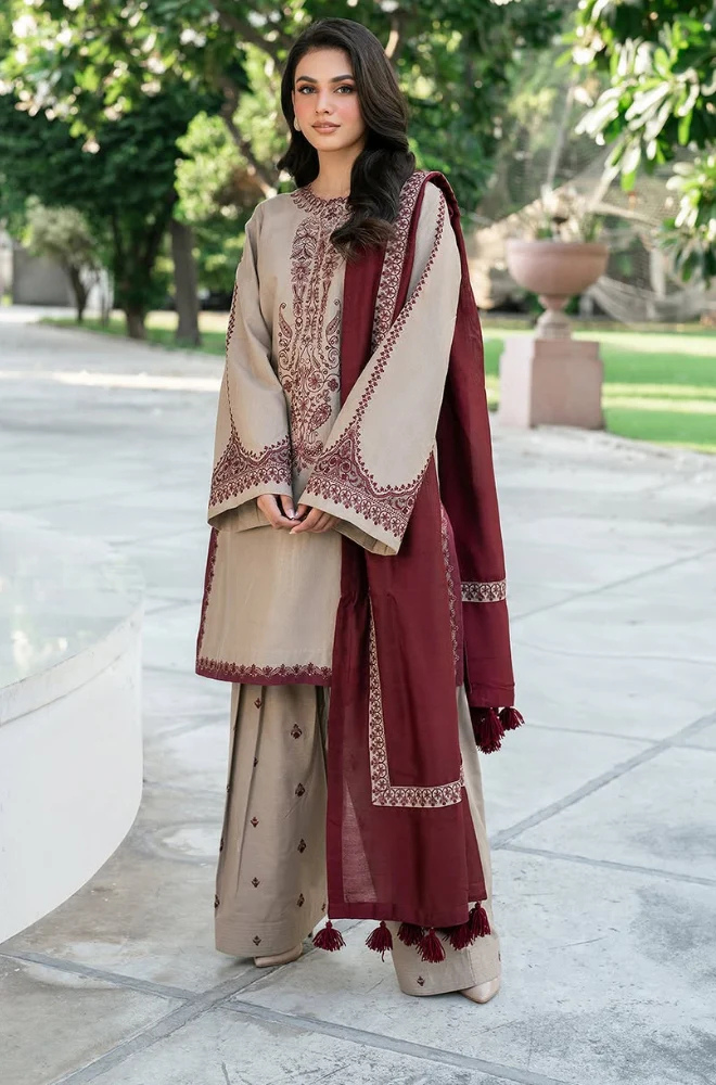 A woman in a fashionable beige and maroon suit, radiating professionalism and grace in her appearance.