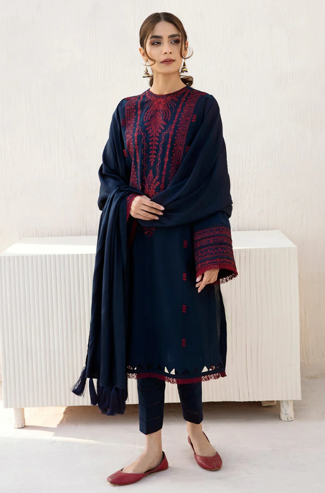 A model in a navy blue kurta suit with red embroidery, representing a fusion of contemporary design and traditional craftsmanship.