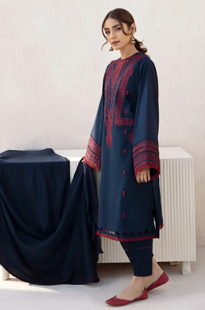 A model elegantly dressed in a navy blue kurta suit, embellished with striking red embroidery, highlighting cultural artistry.