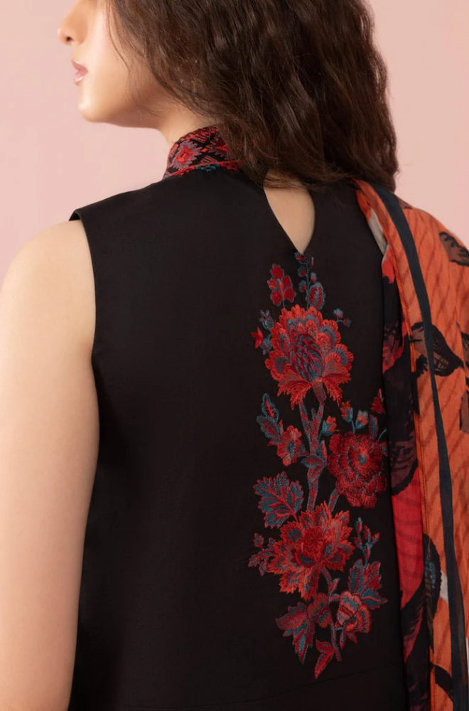 A woman’s back is shown, adorned in a black and red floral print dress, highlighting the vibrant design and elegant silhouette.