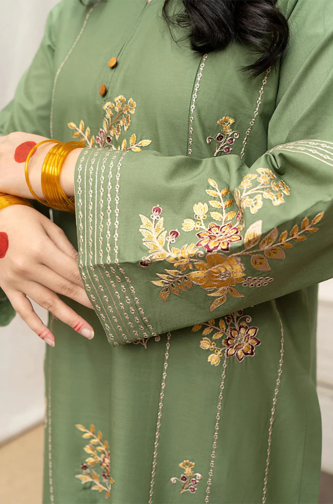  A woman in a green embroidered kurta adorned with intricate gold embroidery, showcasing traditional elegance and style.
