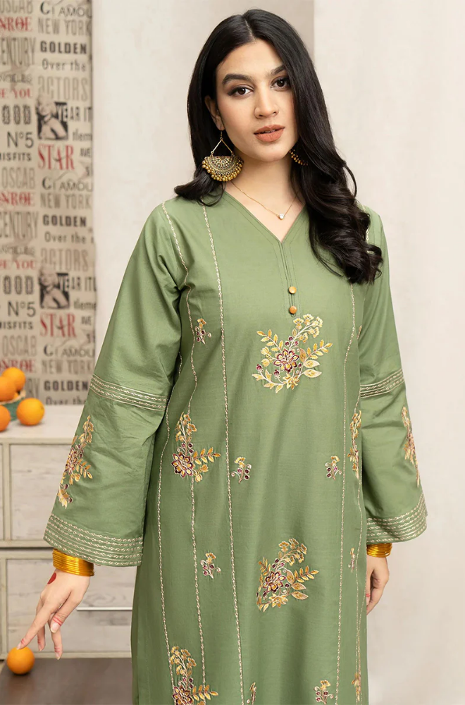 A woman in a stylish green kurta suit and pants, showcasing traditional fashion with a modern touch.
