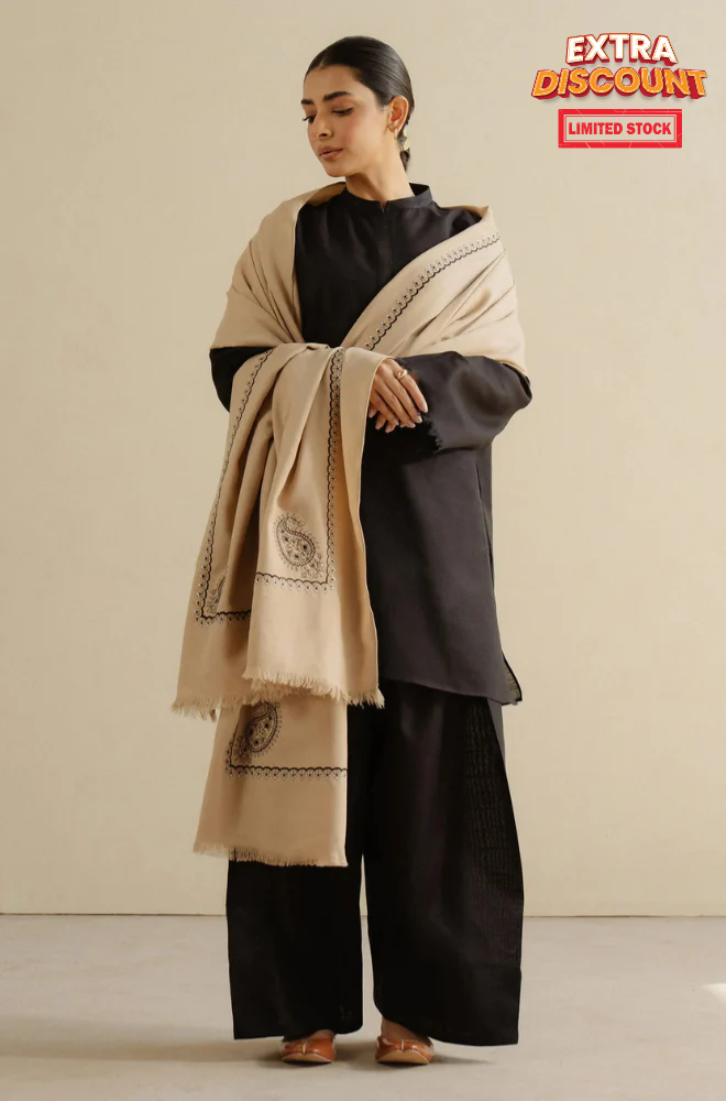 A woman in a fashionable black and beige shawl, embodying grace and style in her attire.