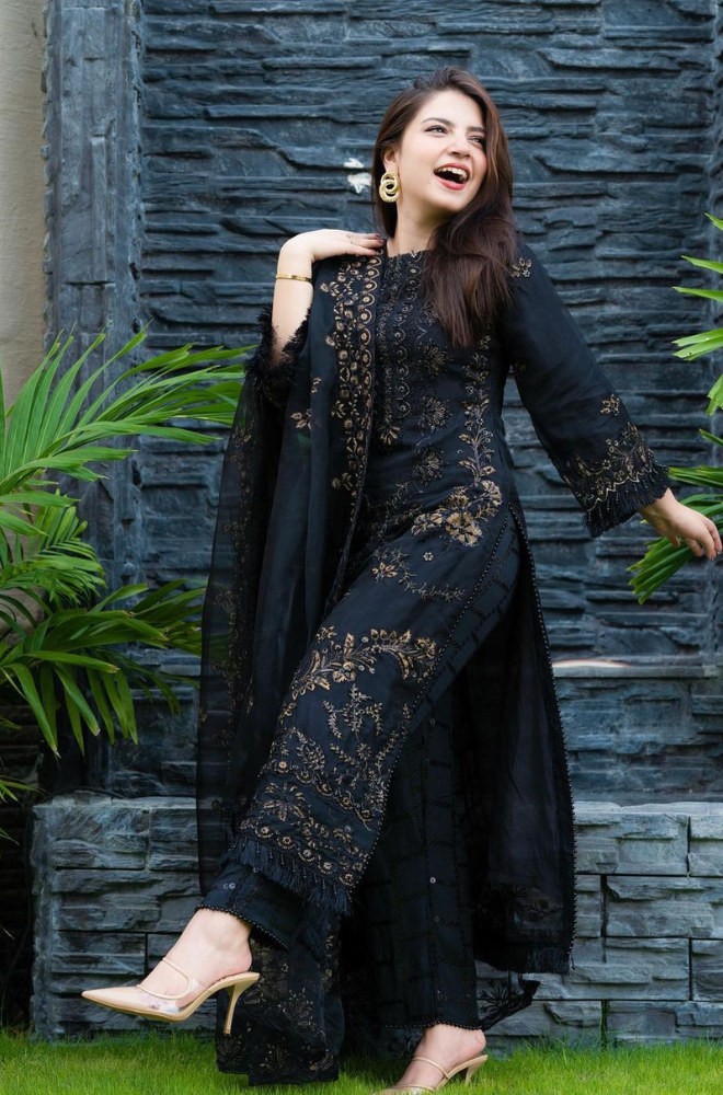 A sophisticated black suit adorned with intricate embroidery, accompanied by a matching dupatta featuring similar embellishments.